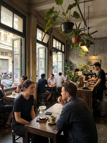Warm afternoon ambience at the coffee shop with patrons chatting under dim lighting