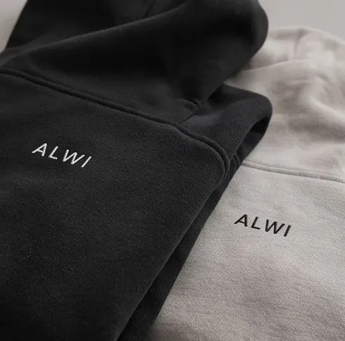 Alwi Essential Hoodie in vibrant orange and charcoal, draped to show its premium heavyweight structure
