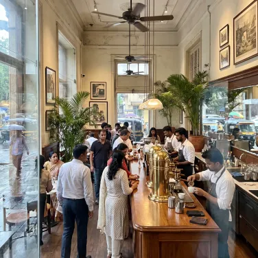 The busy open bar during morning rush, brass fixtures gleaming