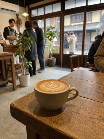 A signature latte with rosetta art on a solid wooden table
